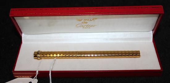 Must de Cartier gold-plated engine-turned ballpoint pen, trinity ring to cap end, red Cartier box